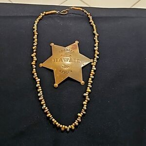 Hawaiian necklace and sheriff badge